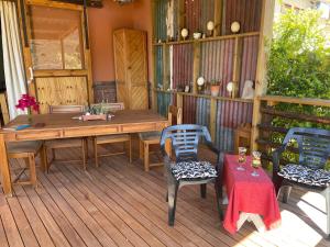 a porch with a table and chairs on a deck at Bokmakierie Studio in Montagu