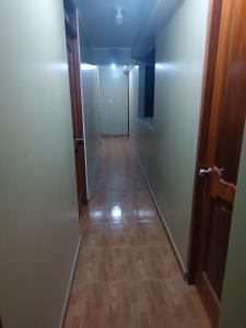 a hallway with a long corridor with a wooden floor at Hostal JM in Huancayo