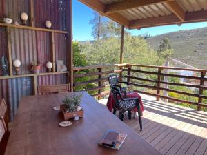a wooden porch with a table and chairs on a deck at Bokmakierie Studio in Montagu
