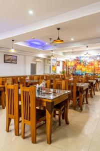 a dining room with wooden tables and chairs at Hotel Kiara Grand - Near Mahipalpur Main Market in New Delhi