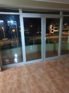 a room with glass windows with a view of a street at Hostal JM in Huancayo