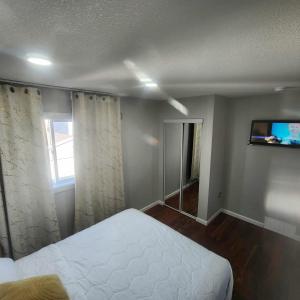 a bedroom with a bed and a tv on the wall at Modern Family Home with guest heat garage, Pet-Friendly!- NO BASEMENT in Edmonton