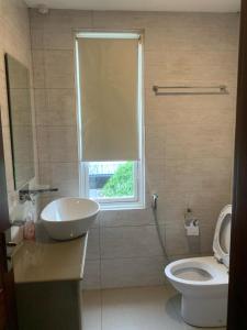 une salle de bain avec toilettes, lavabo et fenêtre dans l'établissement Crown Luxury Apartment 2 Bed Room Apartment, à Colombo