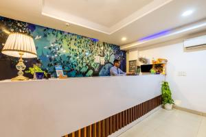a man standing at a bar in a restaurant at Hotel Kiara Grand - Near Mahipalpur Main Market in New Delhi