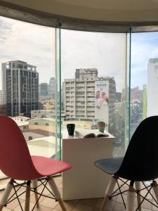 uma sala com duas cadeiras e vista para uma cidade em Music City Inn em Kaohsiung