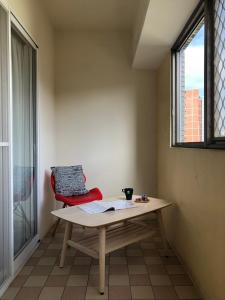 uma mesa e uma cadeira num quarto com uma janela em Music City Inn em Kaohsiung
