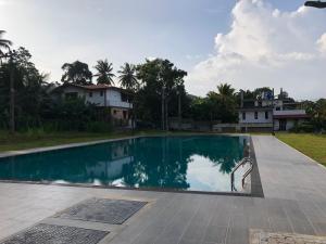 a swimming pool in front of a house at Viyathpura in Nikawatawana
