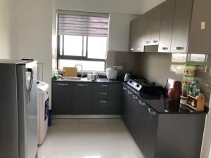 a kitchen with gray cabinets and a black refrigerator at Viyathpura in Nikawatawana