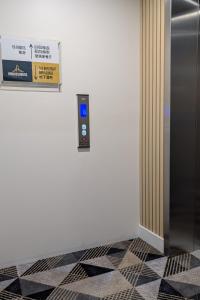 a elevator in a room with a sign on the wall at Ambassadors Hotel in Adelaide
