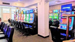 a row of slot machines in a room with chairs at Ambassadors Hotel in Adelaide +14 photos