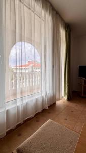Zimmer mit einem großen Fenster und weißen Vorhängen in der Unterkunft Fantastic Apartment in Sveti Vlas in Sweti Wlas