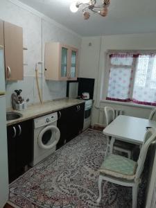 a small kitchen with a table and a sink at 7 дом у моря in Aktau