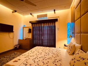 een slaapkamer met een bed en een televisie. bij Crest View Guest House Islamabad in Islamabad