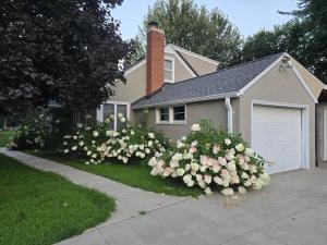 a house with a bunch of flowers in front of it at Spacious and Cozy 4-Bedroom Home in the heart of MSP in Saint Paul