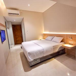 a bedroom with a large white bed in it at Hotel Kebon Kana Kaliurang in Kaliurang