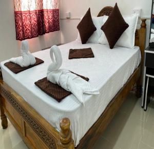 a bed with two swans made out of towels at kavieya residency in Pūrnānkuppam
