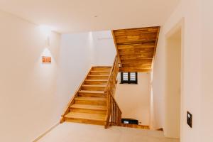 a staircase in a white room with wooden rails at Wine & boutique hotel Terbotz in Štrigova