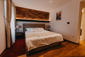 a bedroom with a large bed with a brick wall at Wine & boutique hotel Terbotz in Štrigova