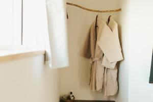 a rack of clothes hanging on a wall next to a window at Matar baYaar מטר ביער in El-Rom
