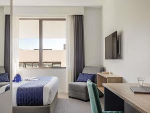 Una habitación de hotel con una cama, una silla y un escritorio. en Mantra MacArthur Hotel, en Canberra