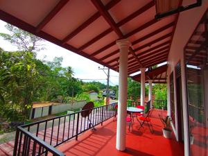 a patio with a table and chairs on a deck at Villa Piore in Mirissa