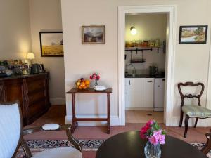 a living room with a table and a kitchen at Rowan Brae Historic Guesthouse in Blackheath