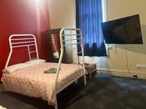 a bedroom with a bunk bed and a flat screen tv at Commercial Hotel Dowerin in Dowerin