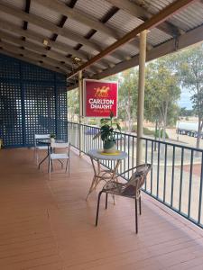 a patio with chairs and a table and a sign at Commercial Hotel Dowerin in Dowerin