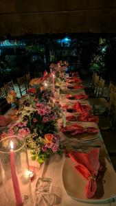 a long table with plates and flowers and candles at Pavana Hotel in Negombo +86 photos