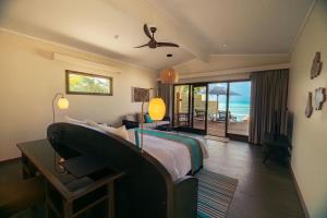 a bedroom with a bed and a view of the ocean at Nala Maldives by Jawakara in Lhaviyani Atoll