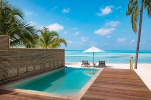 a pool on the beach with a view of the ocean at Nala Maldives by Jawakara in Lhaviyani Atoll