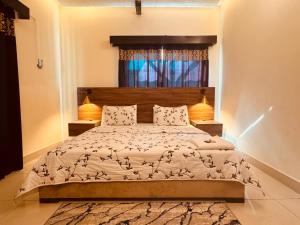 een slaapkamer met een groot bed met twee lampen bij Crest View Guest House Islamabad in Islamabad