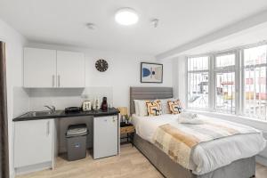 a bedroom with a bed and a desk in it at Bright and Cozy Studio Flat for a Relaxing Stay in Greenford