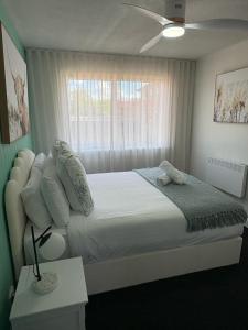 a bedroom with a large bed and a window at Stylish Haven with a Touch of Colour - Hosted by Canstay in Downer