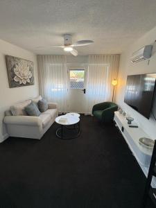 a living room with a couch and a table at Stylish Haven with a Touch of Colour - Hosted by Canstay in Downer