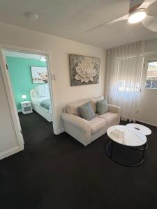 a living room with a couch and a bed at Stylish Haven with a Touch of Colour - Hosted by Canstay in Downer +9 photos