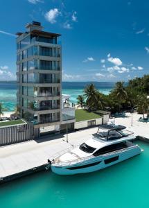 a boat docked at a marina next to a building at Swarn by Hawks Hotels Kamadhoo Baa Atoll in Baa Atoll