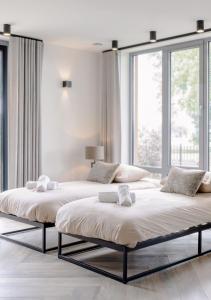 two beds in a white room with large windows at 4-bed Apartment Kitchen Free Parking in Ledeacker