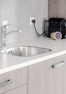 a white sink in a bathroom with a black bag at 4-bed Apartment Kitchen Free Parking in Ledeacker +17 photos