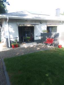 a red chair sitting in front of a house at Columbae Guesthouse in Parys