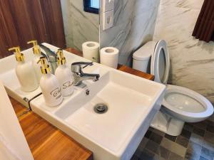 a bathroom with a white sink and a toilet at Andewi Cabin in Sempidi +8 photos