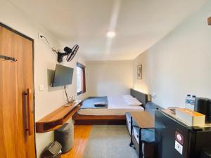 a small room with a bed and a desk at Andewi Cabin in Sempidi