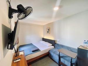 a small room with a bed and a television at Andewi Cabin in Sempidi