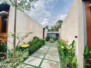 a garden with a walkway between two buildings at Andewi Cabin in Sempidi