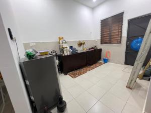 a kitchen with a table and a counter in a room at HASYA Guesthouse Seri Iskandar in Seri Iskandar