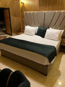 a large bed with white pillows and black sheets at Kylie magic camp in Wadi Rum +144 photos