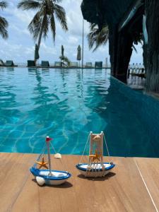 Zwei Spielzeugboote stehen neben einem Schwimmbecken. in der Unterkunft Dreamland Resort in Thong Nai Pan Yai
