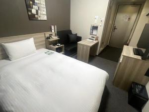 a bedroom with a large white bed in a room at Route Inn Grantia Tokai Spa&Relaxation in Tokai