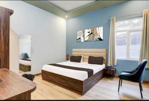 a bedroom with a bed and a desk in it at Hotel O Sultanpur Railway Junction Formerly Sanskar Marriage Lawan in Sultānpur