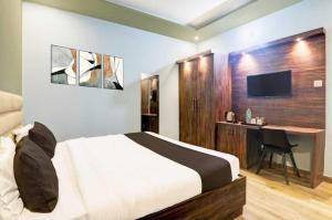 a bedroom with a bed and a desk and a television at Hotel O Sultanpur Railway Junction Formerly Sanskar Marriage Lawan in Sultānpur